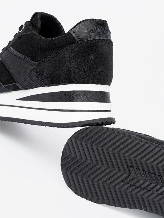 Sneakers nere moderne con dettagli lucidi