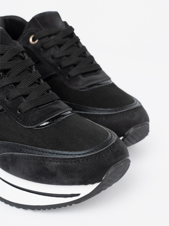 Sneakers nere moderne con dettagli lucidi