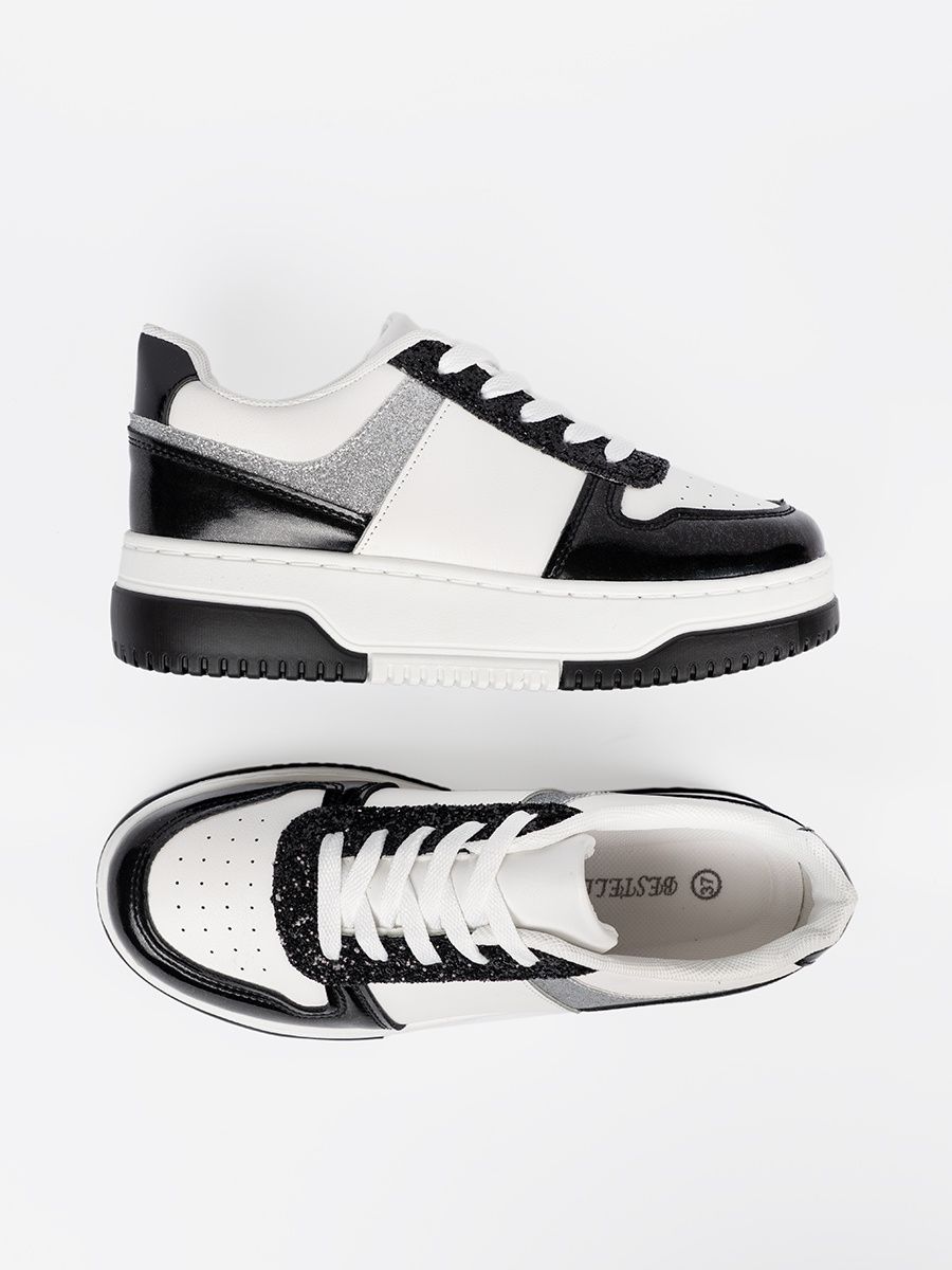 Sneakers nere e bianche con dettagli argentati lucidi