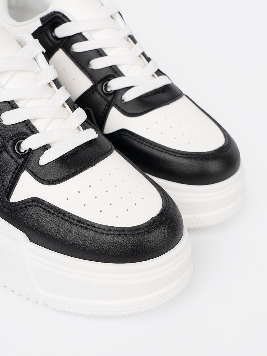 Sneakers neri e bianchi alla moda con suola spessa