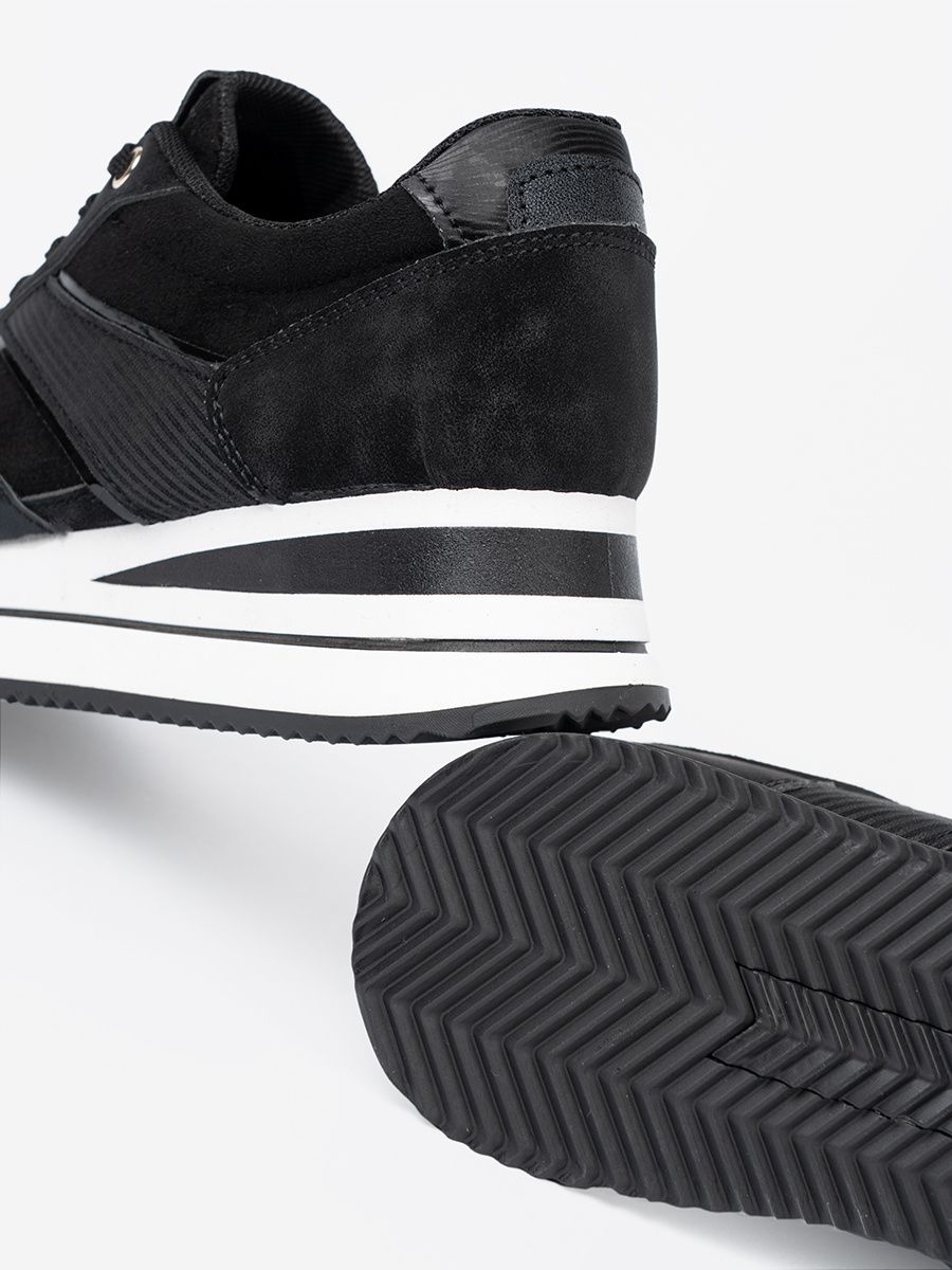 Sneakers nere moderne con dettagli lucidi