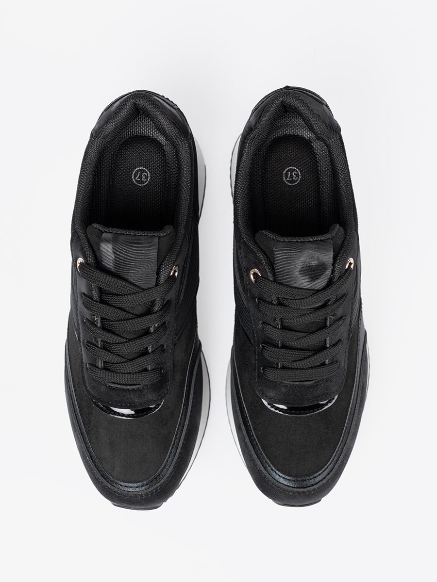 Sneakers nere moderne con dettagli lucidi