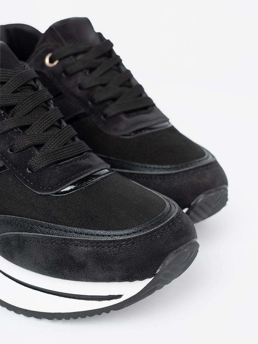 Sneakers nere moderne con dettagli lucidi